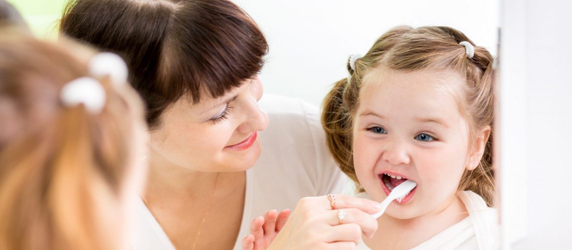21965681 - mother kid brushing kid teeth