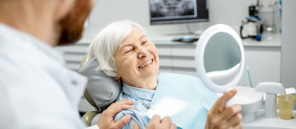 Patient-admiring-smile-after-transitioning-from-dentures-to-dental-implants